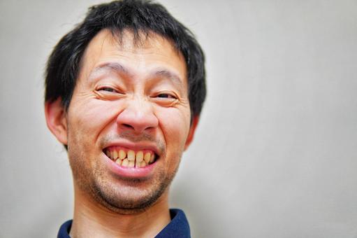 変な顔で笑う男